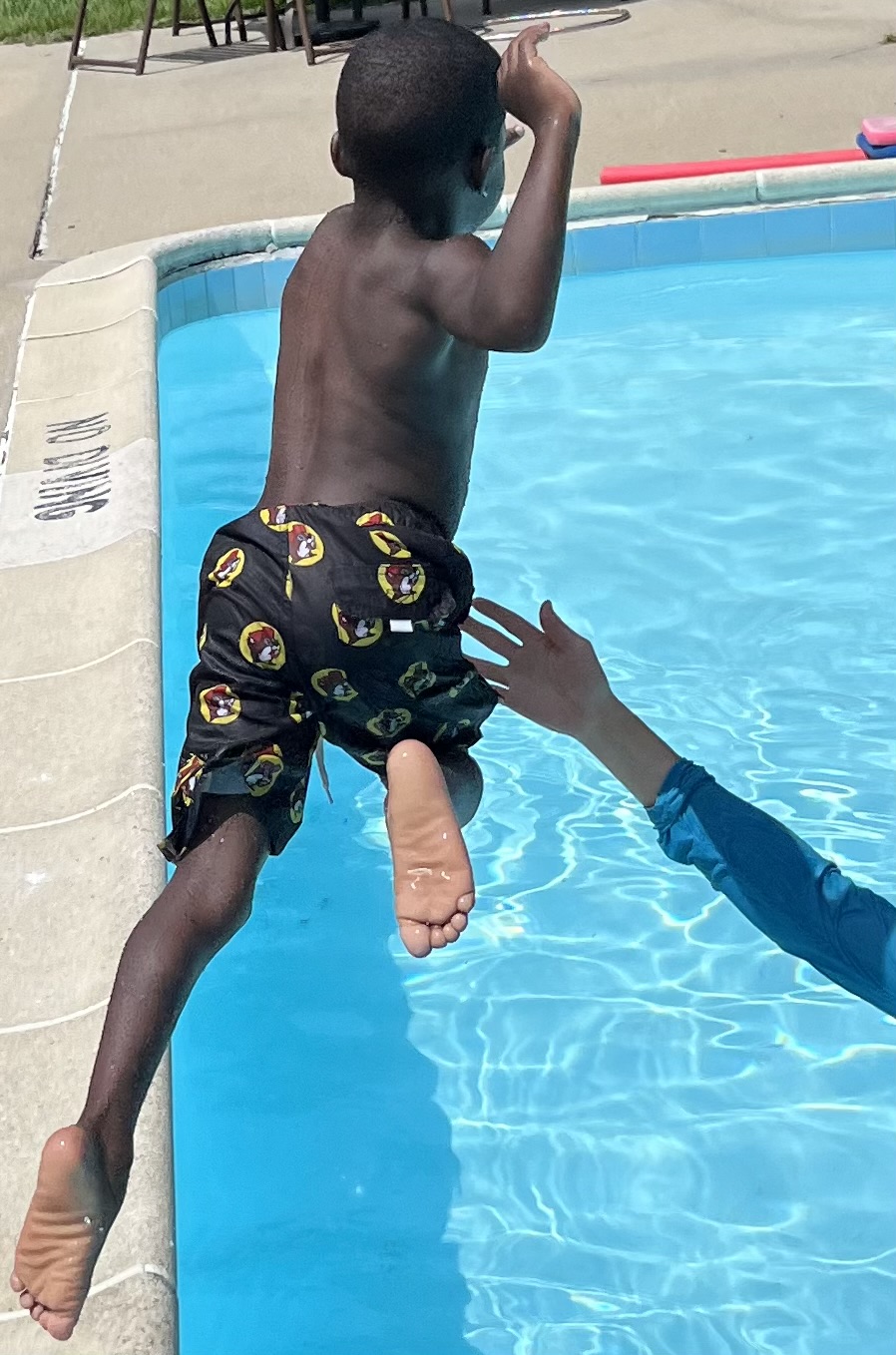 Child jumping into a swimming pool Child jumping into a swimming pool