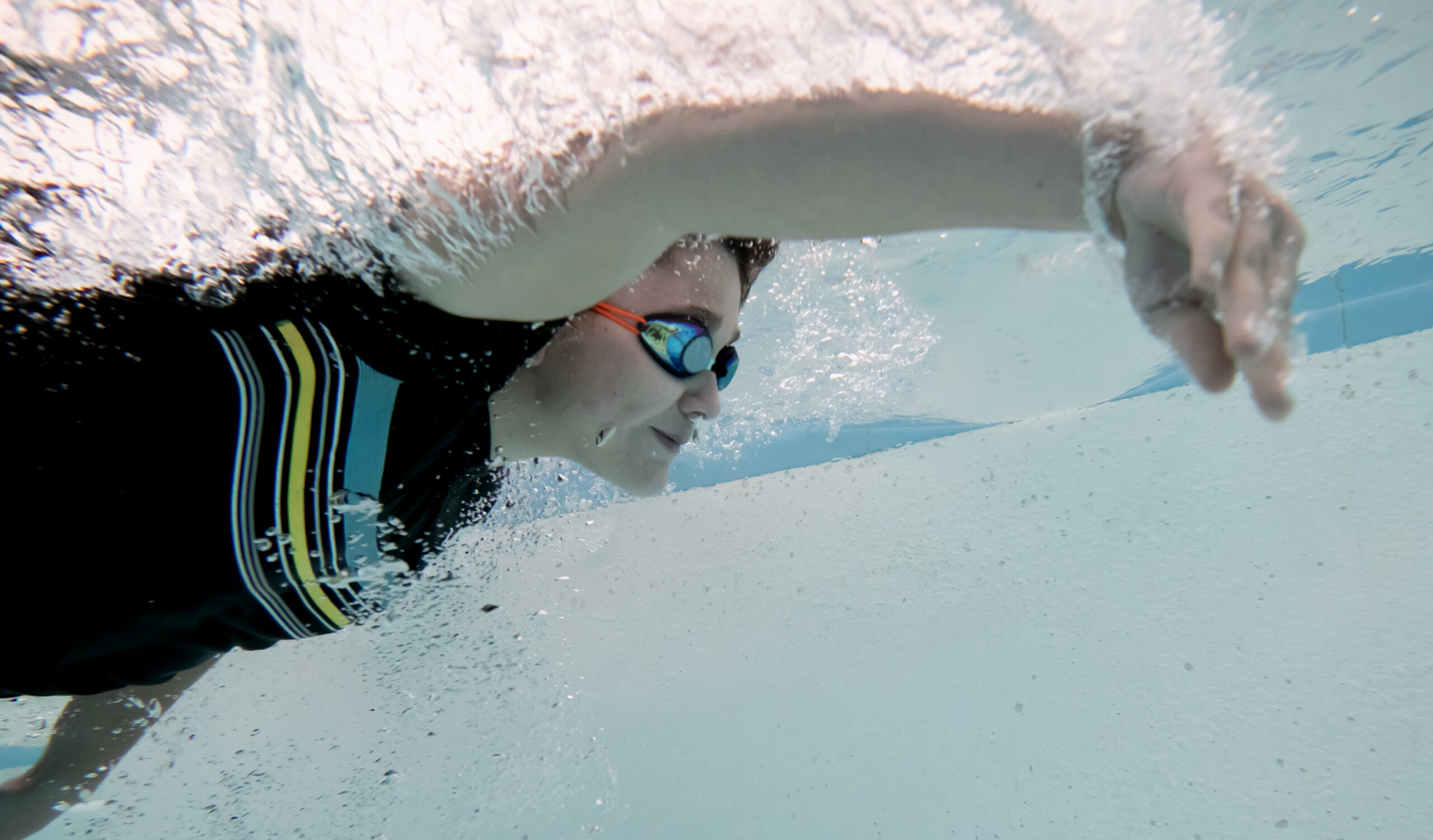 young boy working on freestyle stroke in the water